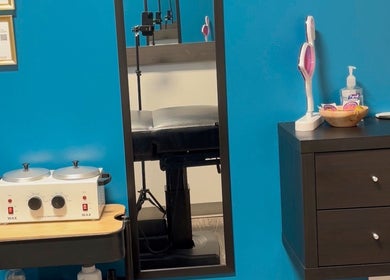 Clean and modern treatment room at Glow With Lindsay in Chicago, Illinois, US, featuring a waxing station.