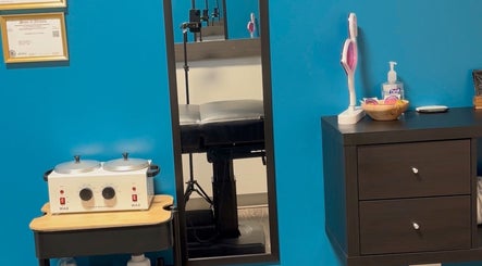 Clean and modern treatment room at Glow With Lindsay in Chicago, Illinois, US, featuring a waxing station.