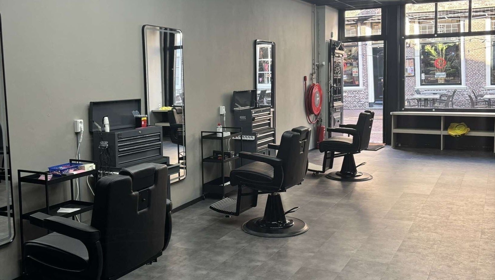 Interieur van Fadez Studio in Brielle, Zuid-Holland, NL, met moderne kappersstoelen en ruime opzet.