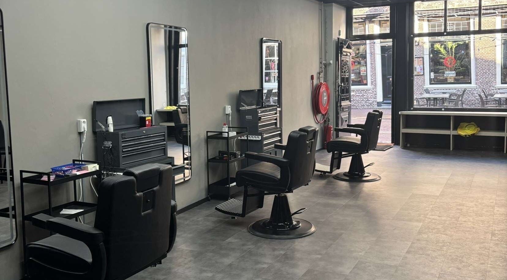 Interieur van Fadez Studio in Brielle, Zuid-Holland, NL, met moderne kappersstoelen en ruime opzet.