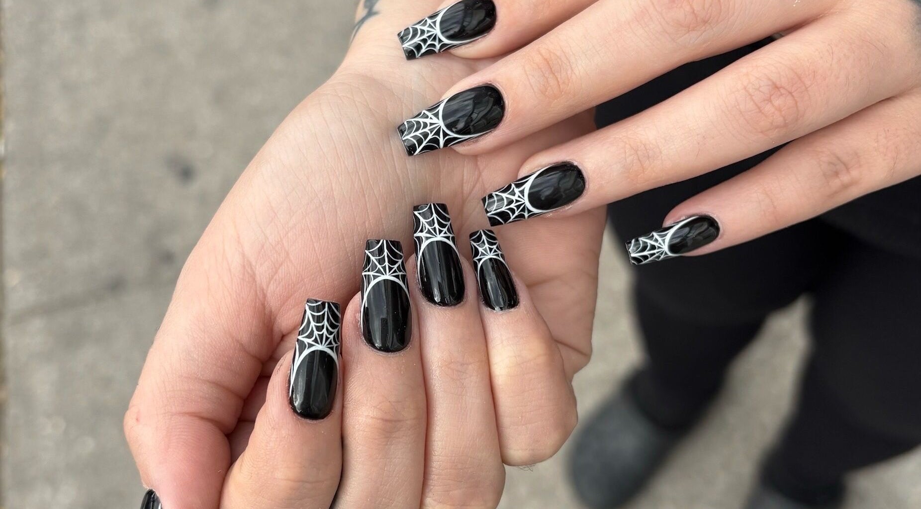 Spiderweb nail art at Nail Haus, Toronto, Ontario, CA, showcasing chic black and white design.