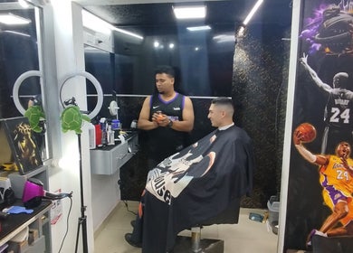 Interior de BarberSchorbogth en Bogotá, Cundinamarca, CO, con cliente y barbero en estación moderna.
