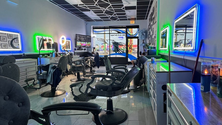 Modern interior of La Familia Barbershop in Chicago, Illinois, US with neon lights and styling chairs.