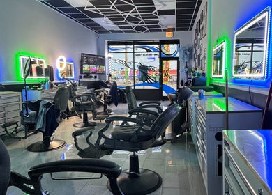 Modern interior of La Familia Barbershop in Chicago, Illinois, US with neon lights and styling chairs.
