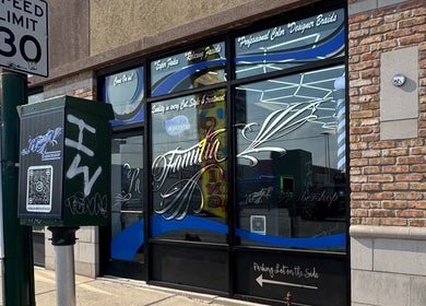 Exterior view of La Familia Barbershop in Chicago, Illinois, highlighting its stylish storefront signage.