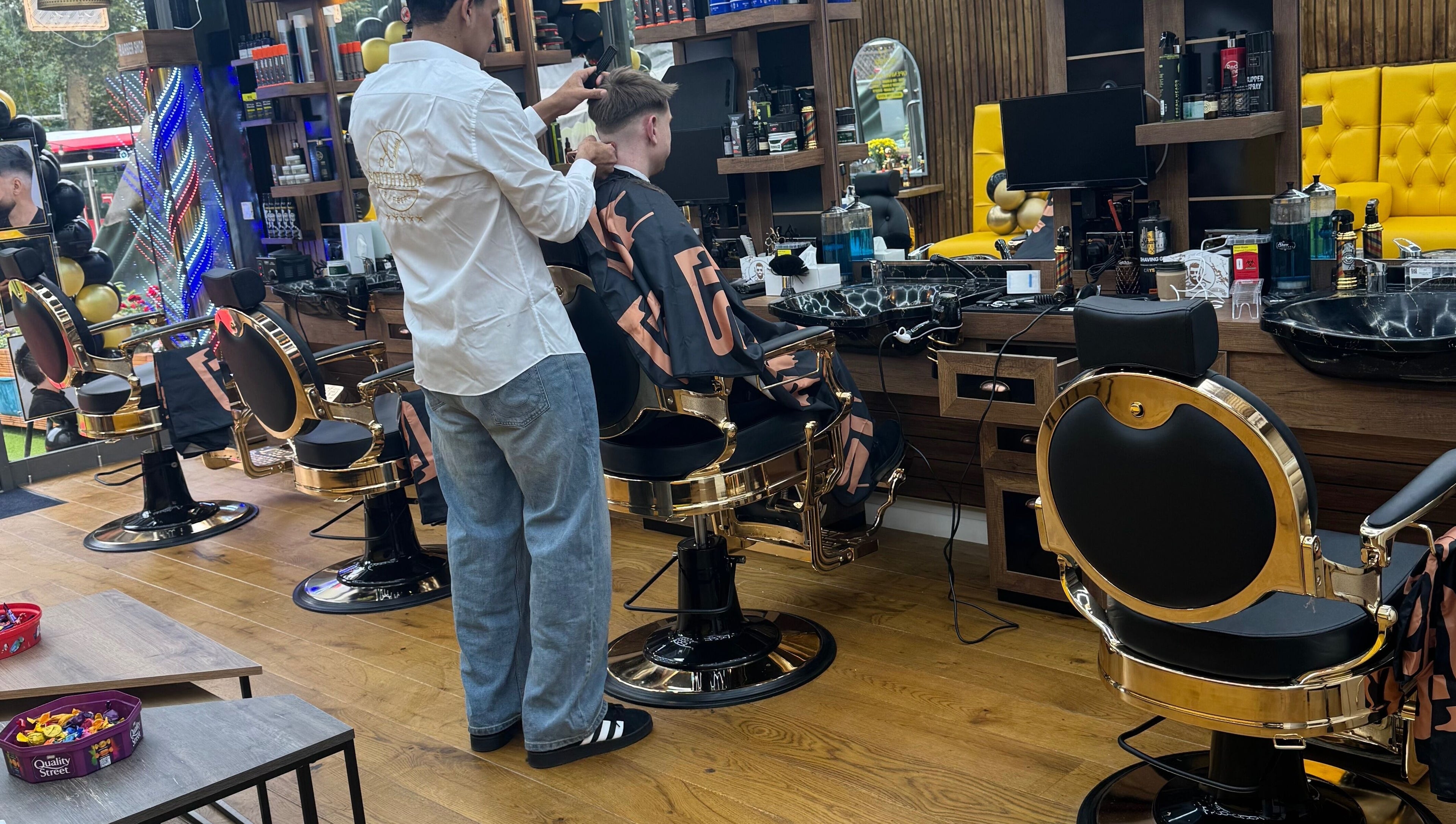 Inside South Fade Barbers, London, England, GB. Stylish barbershop with modern chairs and vibrant decor.