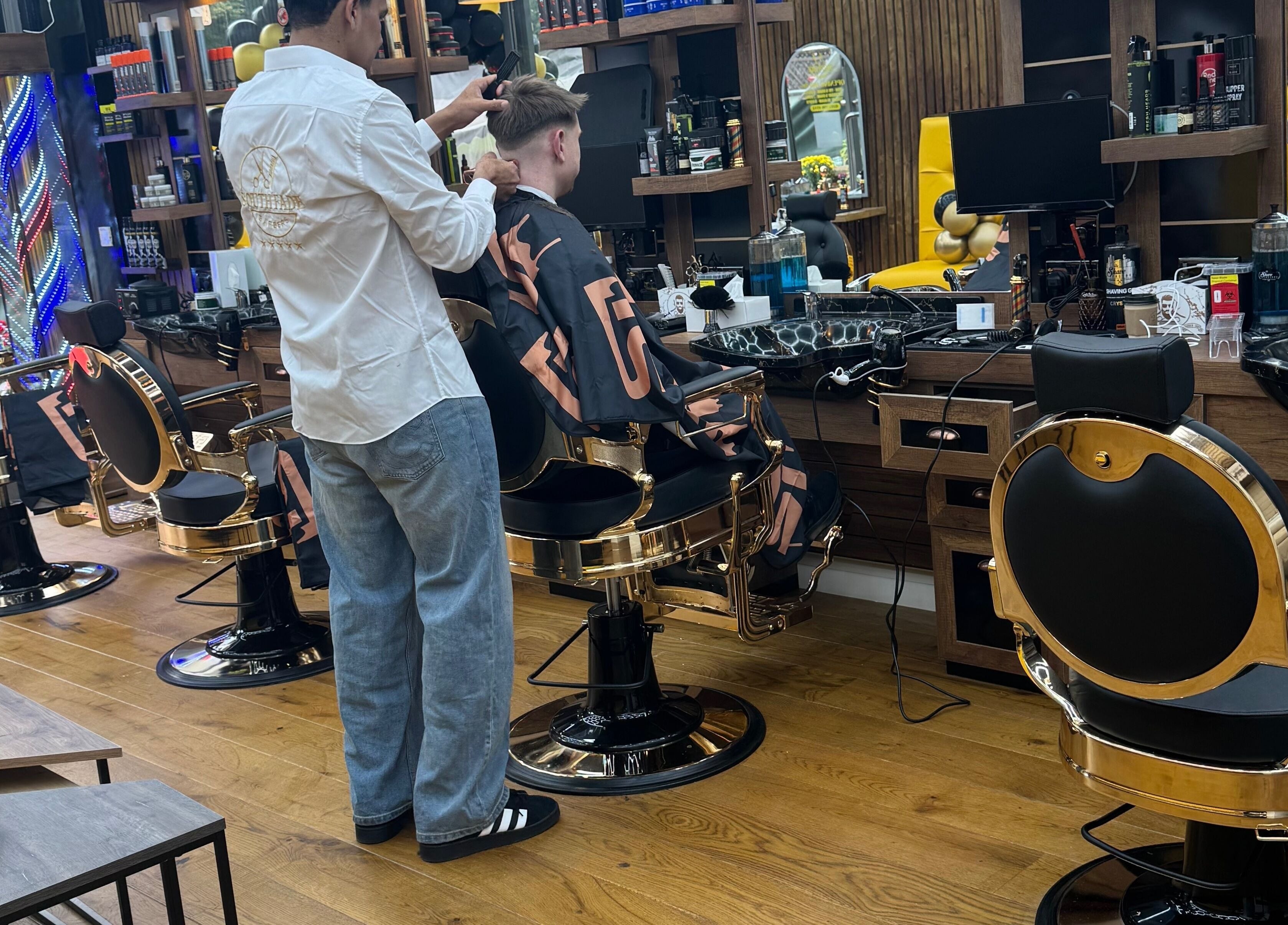 Inside South Fade Barbers, London, England, GB. Stylish barbershop with modern chairs and vibrant decor.