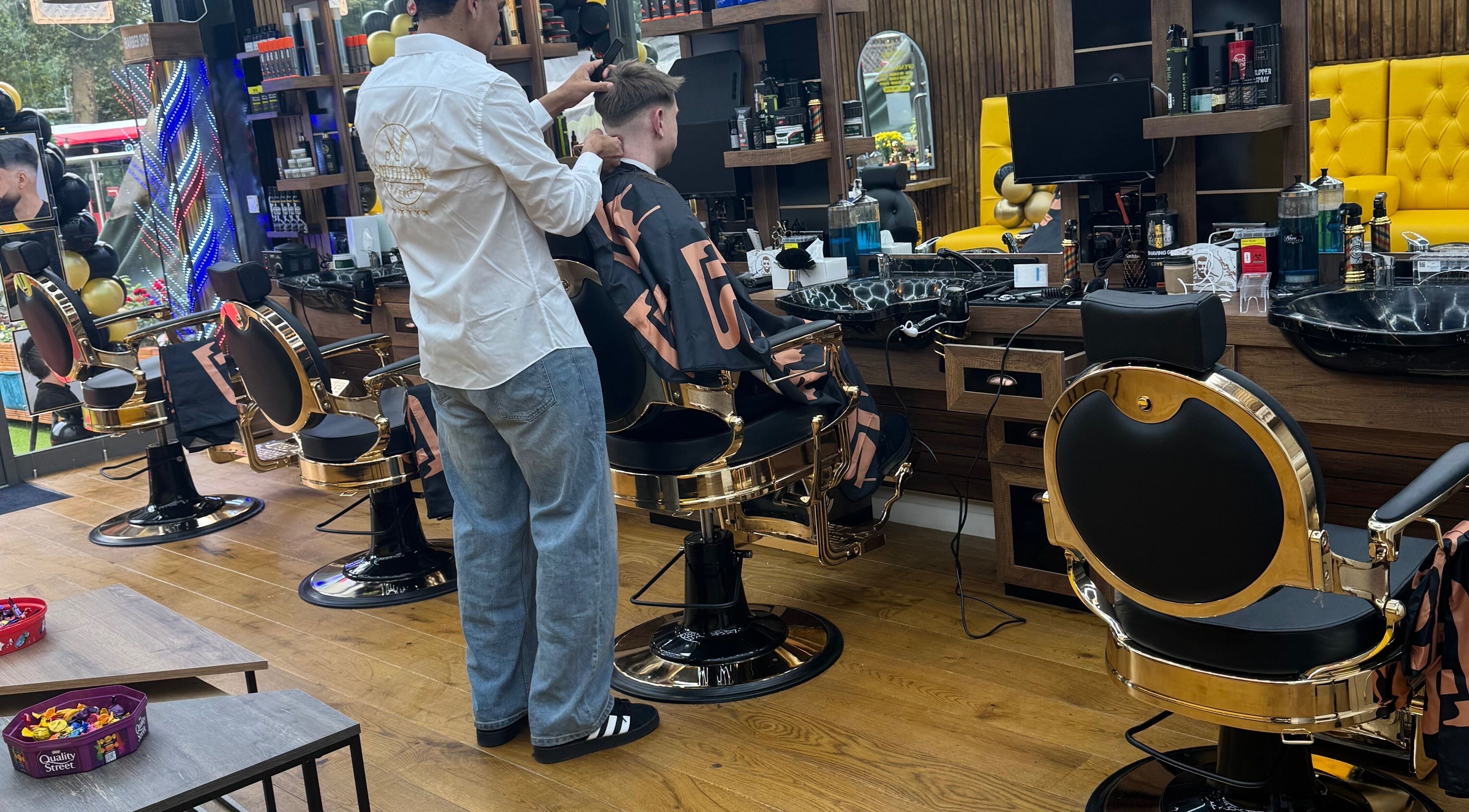 Inside South Fade Barbers, London, England, GB. Stylish barbershop with modern chairs and vibrant decor.