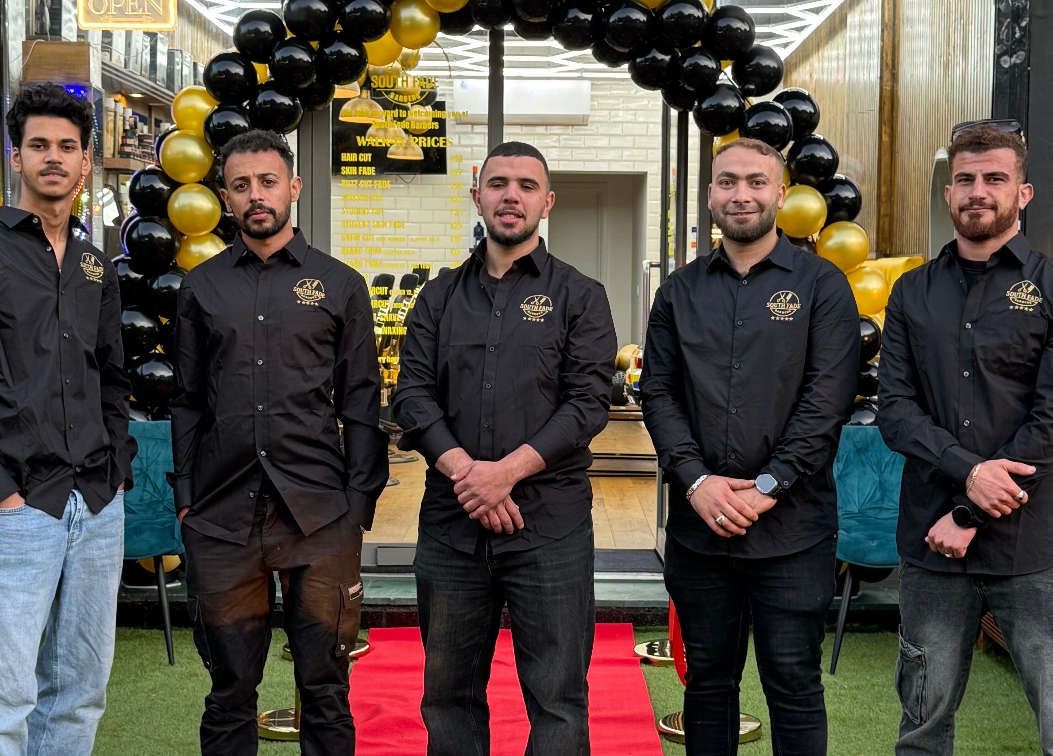 Team outside South Fade Barbers in London, England, GB, ready to welcome customers.