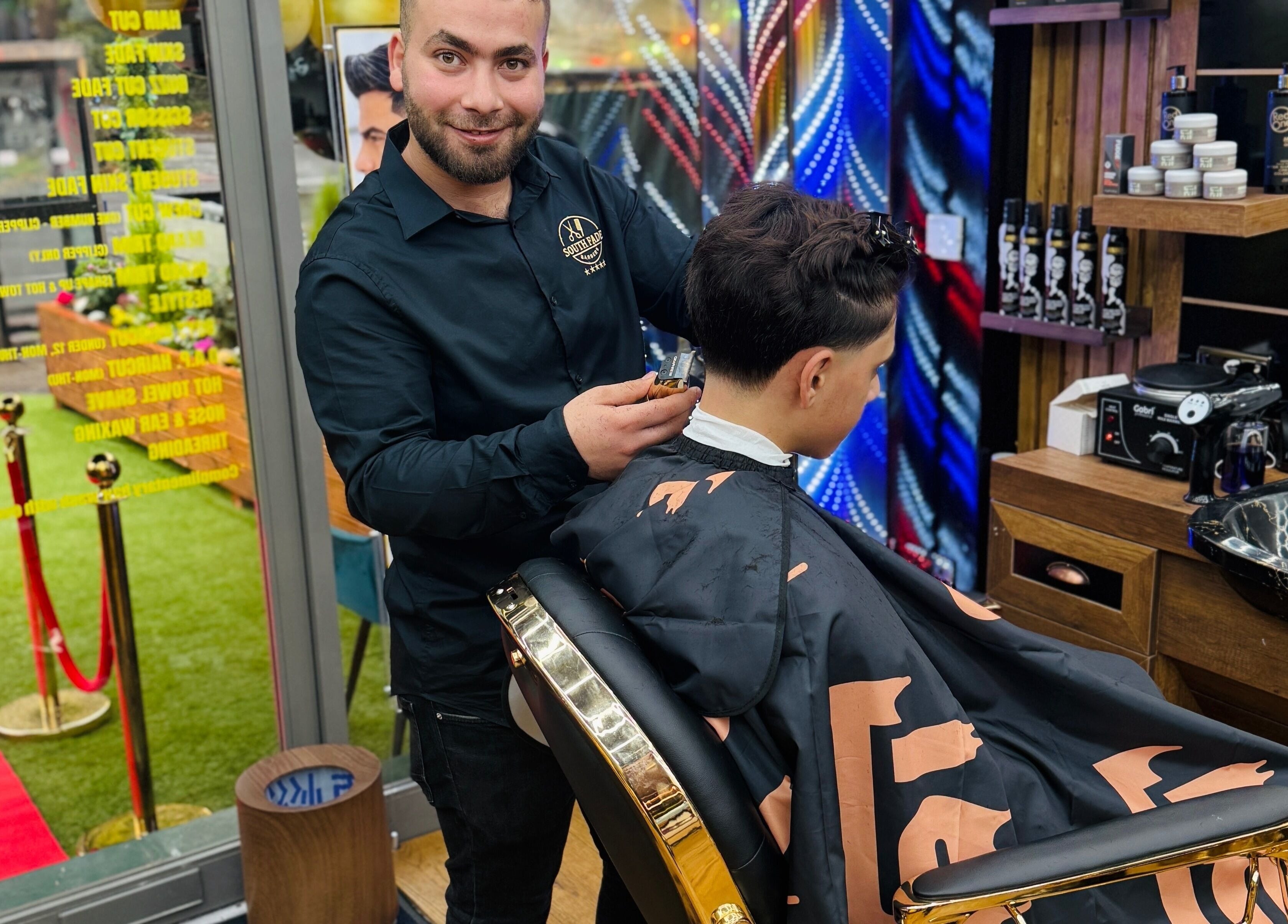 Barber styling a haircut at South Fade Barbers, London, England, GB. Modern interior and professional service.