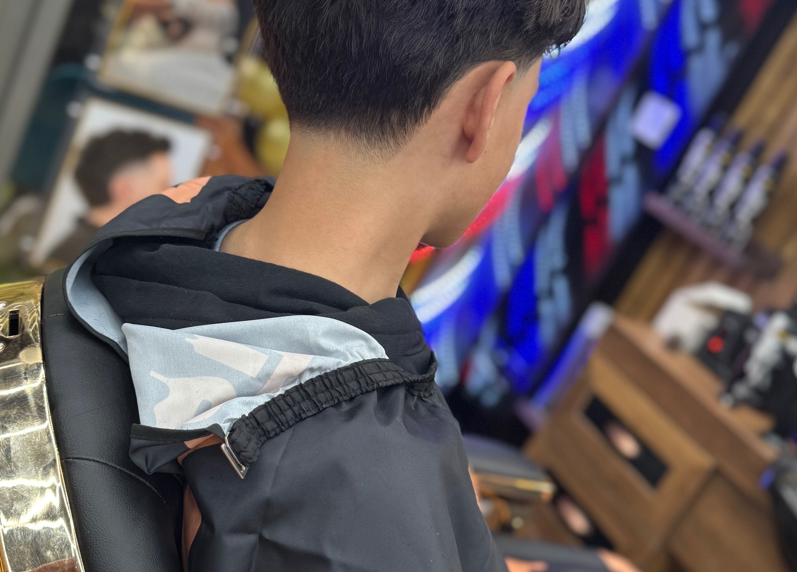 Youthful haircut at South Fade Barbers, London, England, GB, showcasing sleek styling in a modern setting.