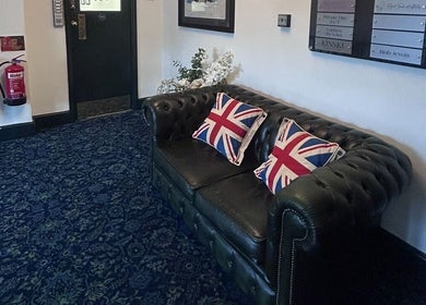 Cozy leather sofa with Union Jack pillows, perfect for relaxation at Wellness by Mariana, Southampton, England, GB.