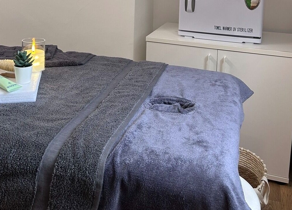 Cozy treatment room at Wellness by Mariana, Southampton, England, GB with soft towels and calming decor.