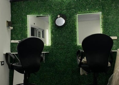 Interior moderno en Alex Wacker, José Marmol, con sillas negras y pared verde iluminada.