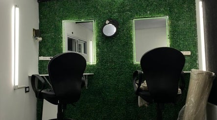 Interior moderno en Alex Wacker, José Marmol, con sillas negras y pared verde iluminada.
