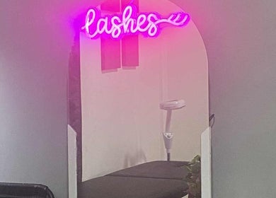 Neón 'lashes' rosa sobre espejo en Estudio Mel Cabrera, Allende, Veracruz, MX. Diseño moderno y acogedor.