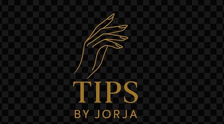 Elegant hand logo for Tips.By.Jorja, a beauty venue in Bay Of Plenty Region, NZ, featuring golden outlines on black.