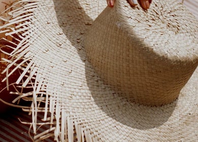 Woven straw hat casting shadows, highlighting summer vibes at Mobile Spray Tan, Cape Town, Western Cape, ZA.