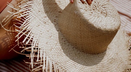Woven straw hat casting shadows, highlighting summer vibes at Mobile Spray Tan, Cape Town, Western Cape, ZA.