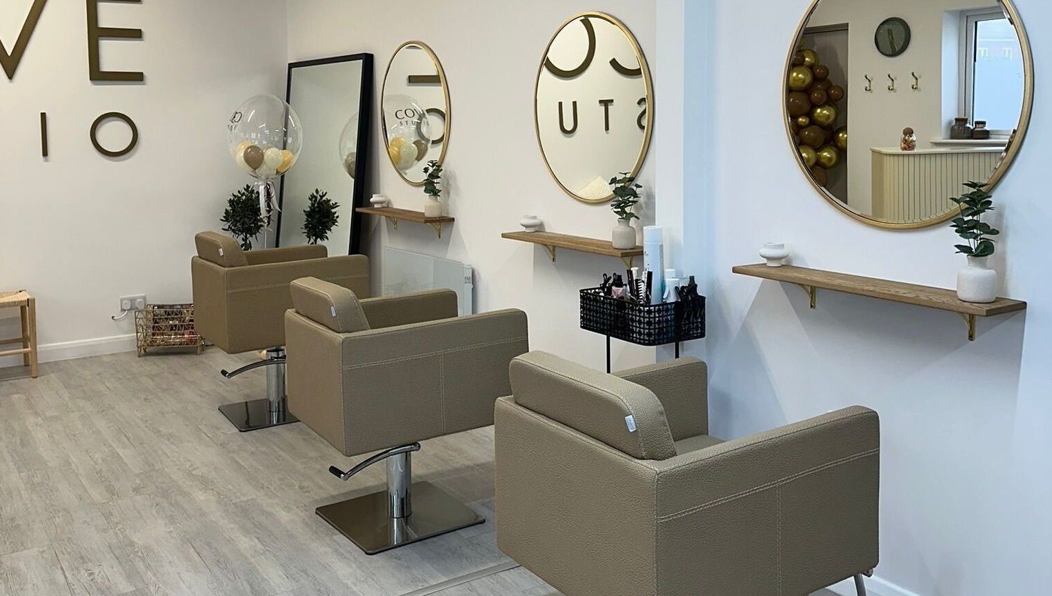 Modern salon interior at Grace Sadler Hair, Broughton Astley, England, GB with stylish seating and round mirrors.