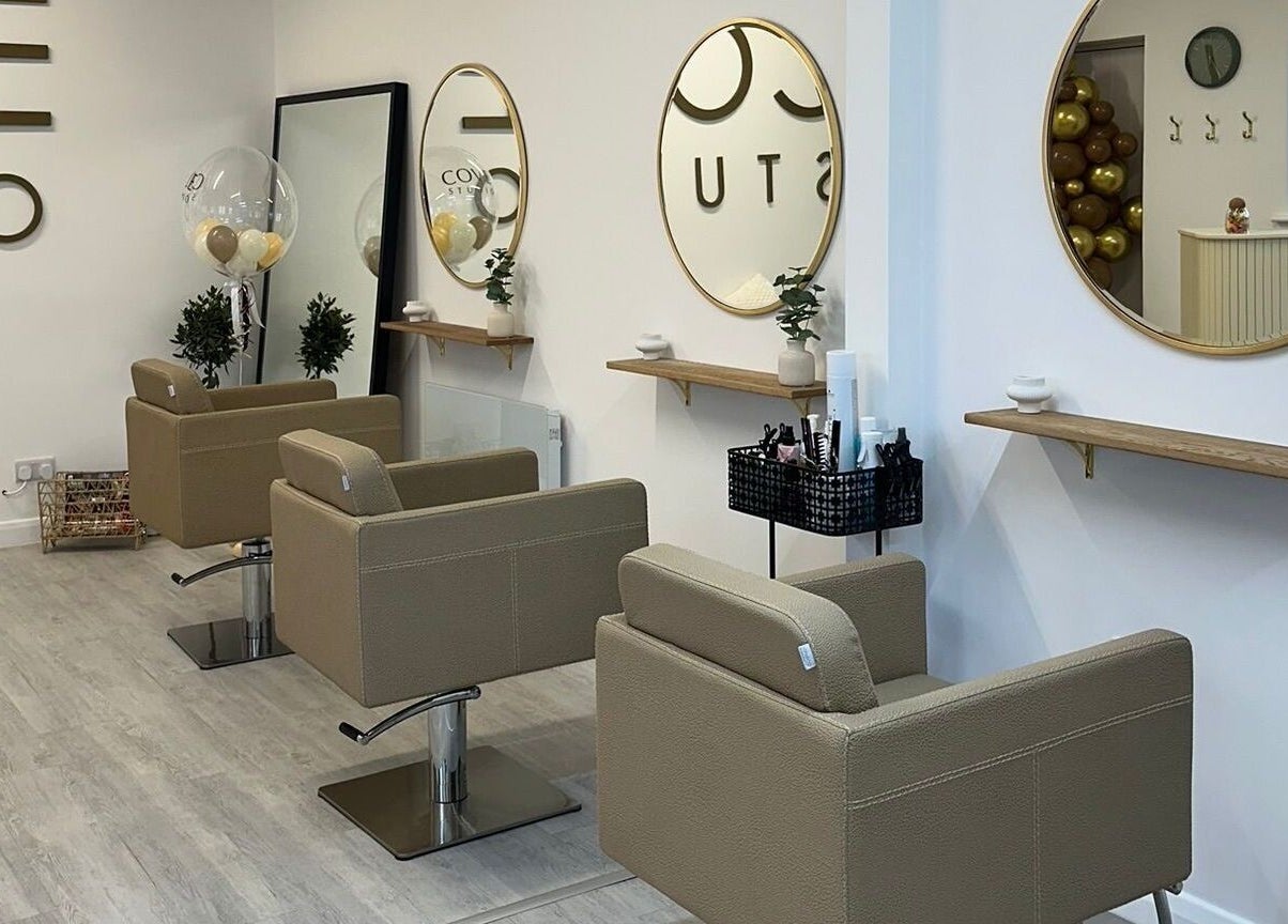Modern salon interior at Grace Sadler Hair, Broughton Astley, England, GB with stylish seating and round mirrors.