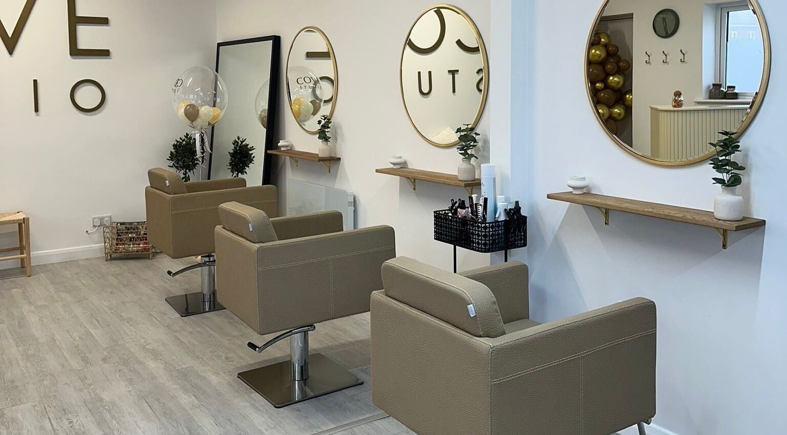 Modern salon interior at Grace Sadler Hair, Broughton Astley, England, GB with stylish seating and round mirrors.