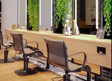 Modern salon chairs at Story 92 House of Beauty in Dubai, Dubai, AE with lush green decor and sleek design.