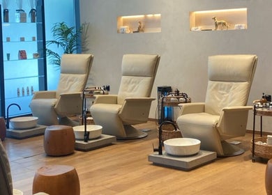 Relaxation area at Story 92 House of Beauty, Dubai, showcases plush chairs and foot spa amenities for treatments.