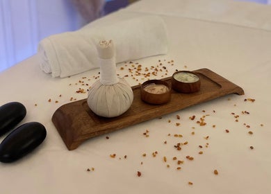 Relaxing spa setup at Story 92 House of Beauty in Dubai, AE featuring massage stones and herbal packs.
