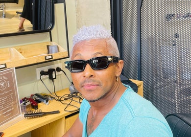 Cliente con estilo moderno en Barbershop Costa Teguise, Costa Teguise, Canarias, ES, posando con gafas.
