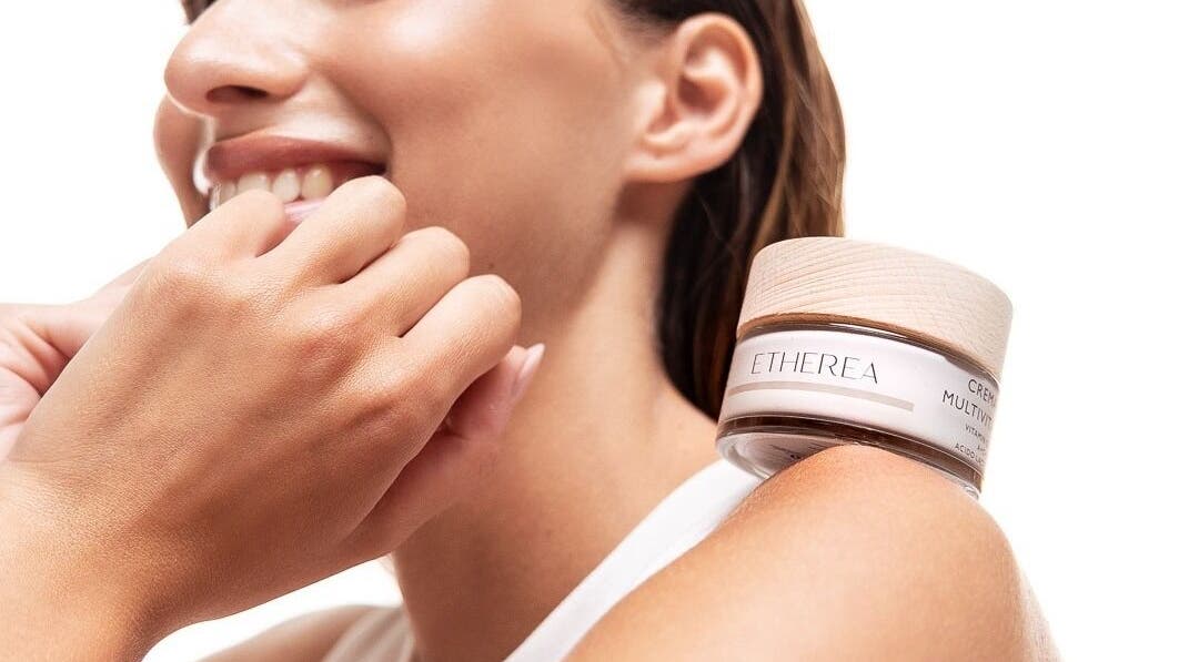 Donna sorridente con crema Etherea sulla spalla ad Aurum Estetica Esclusiva | Locarno, Muralto, Muralto, Ticino, CH.