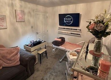 Elegant treatment room at The Beauty Boutique, Plymouth, England, GB with comfy couch and floral decor.