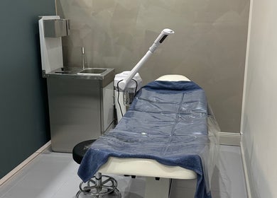 A modern treatment room at iBrow & Lashes Studio, Queanbeyan, New South Wales, AU, featuring a spa bed and sink.