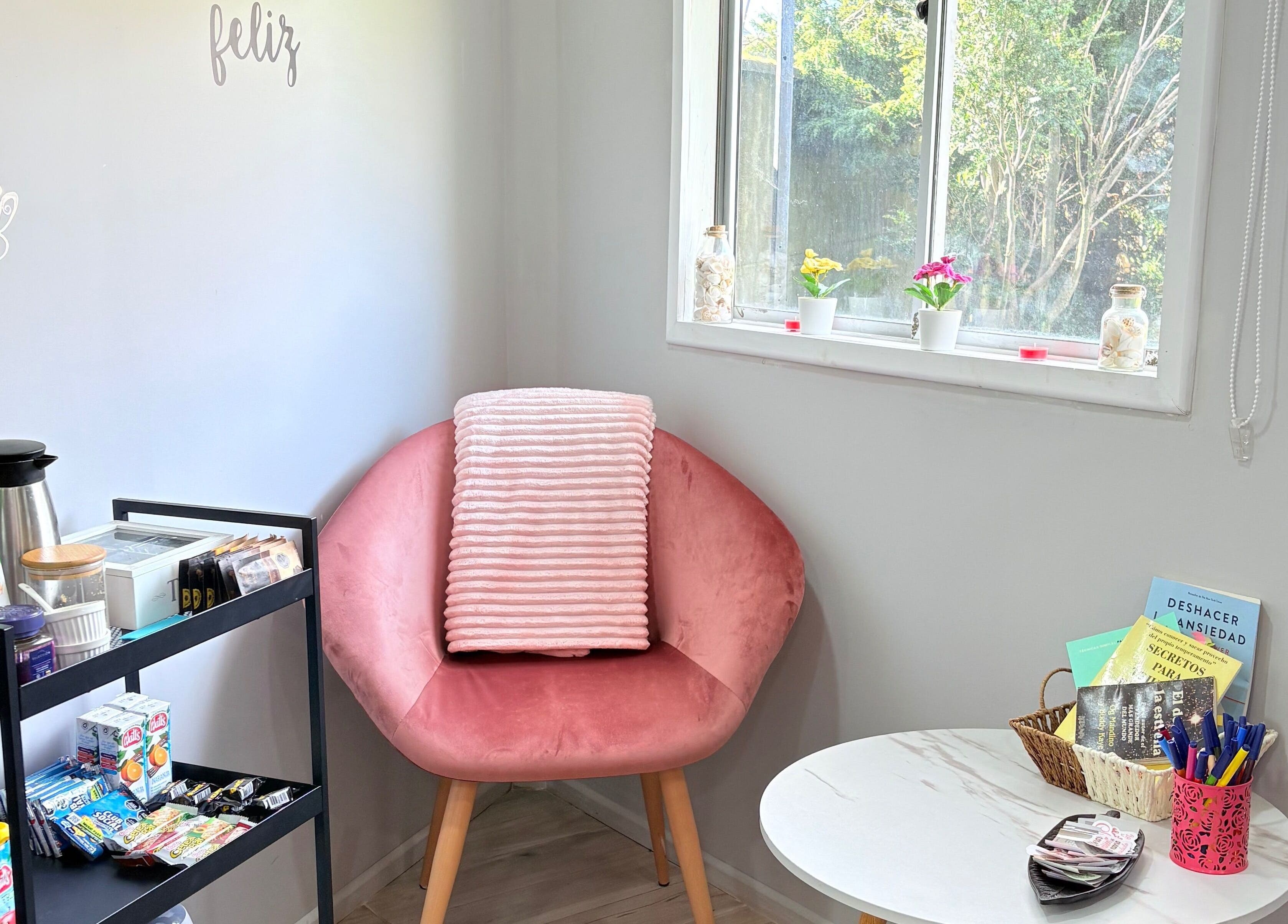 Rincón acogedor en Studio Belleza, Puerto Montt, Los Lagos, CL con silla rosa y bebidas.