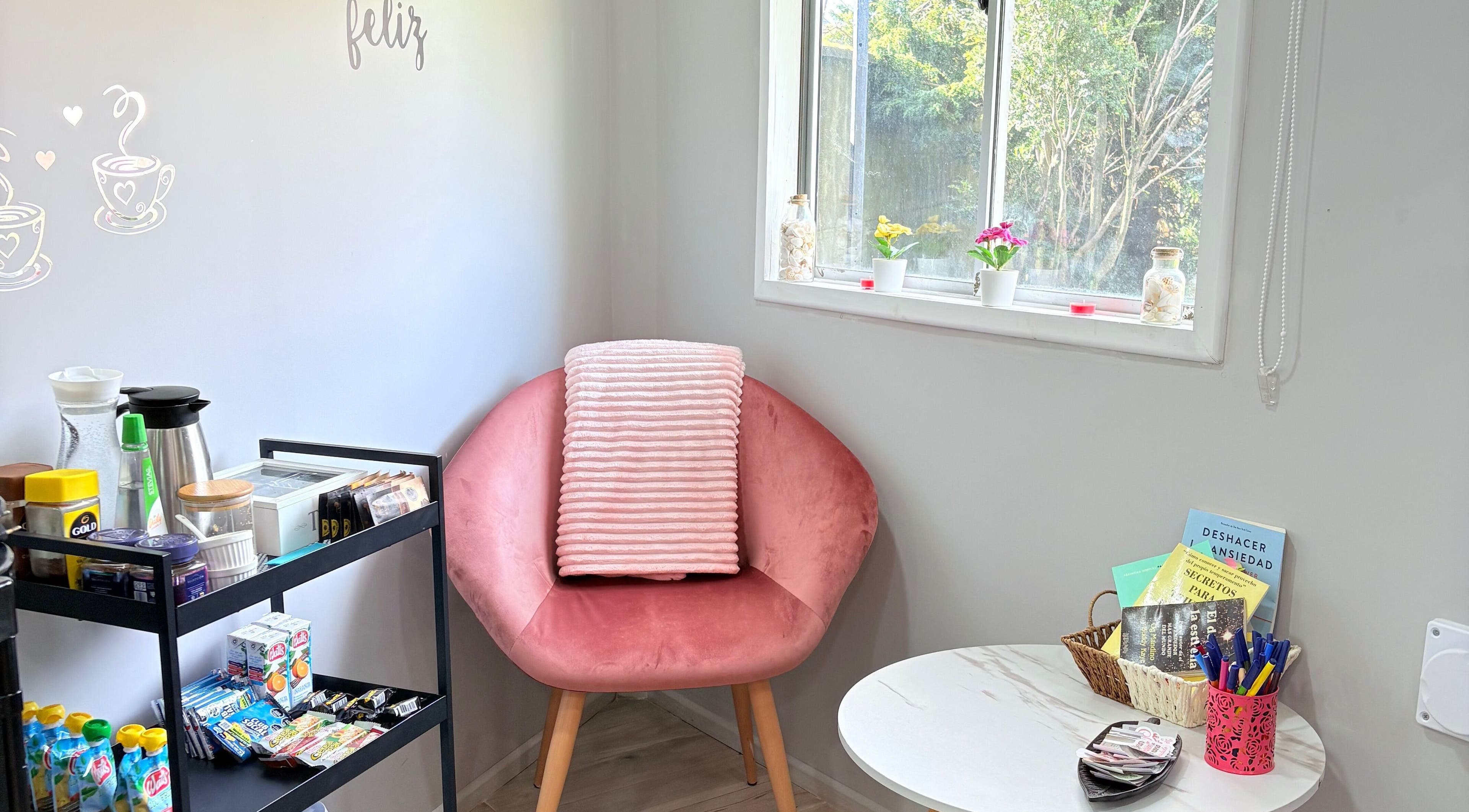 Rincón acogedor en Studio Belleza, Puerto Montt, Los Lagos, CL con silla rosa y bebidas.