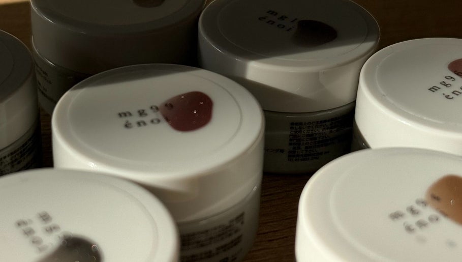 Assorted nail polish pots at Mitts Nails, Edinburgh, Scotland, GB are neatly arranged on a wooden surface.