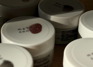 Assorted nail polish pots at Mitts Nails, Edinburgh, Scotland, GB are neatly arranged on a wooden surface.