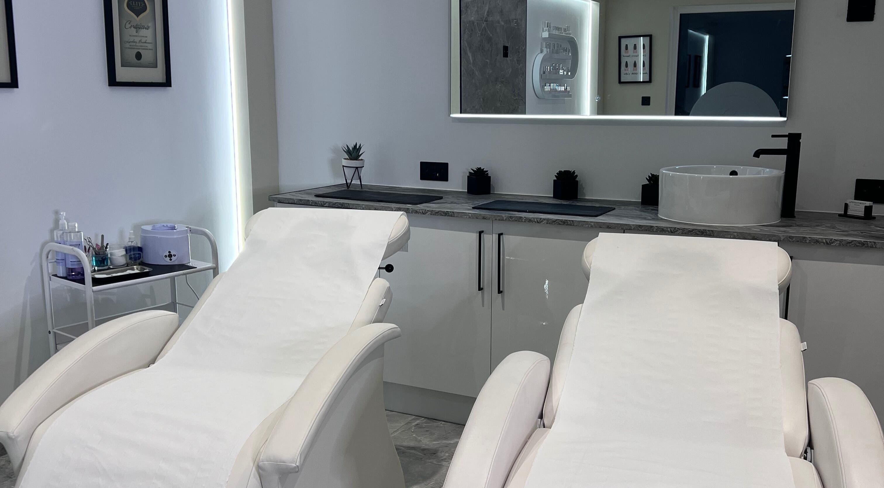 Luxurious treatment room at Beauty Expert Salon & Training, Dennyloanhead, Scotland, GB, featuring plush white chairs.