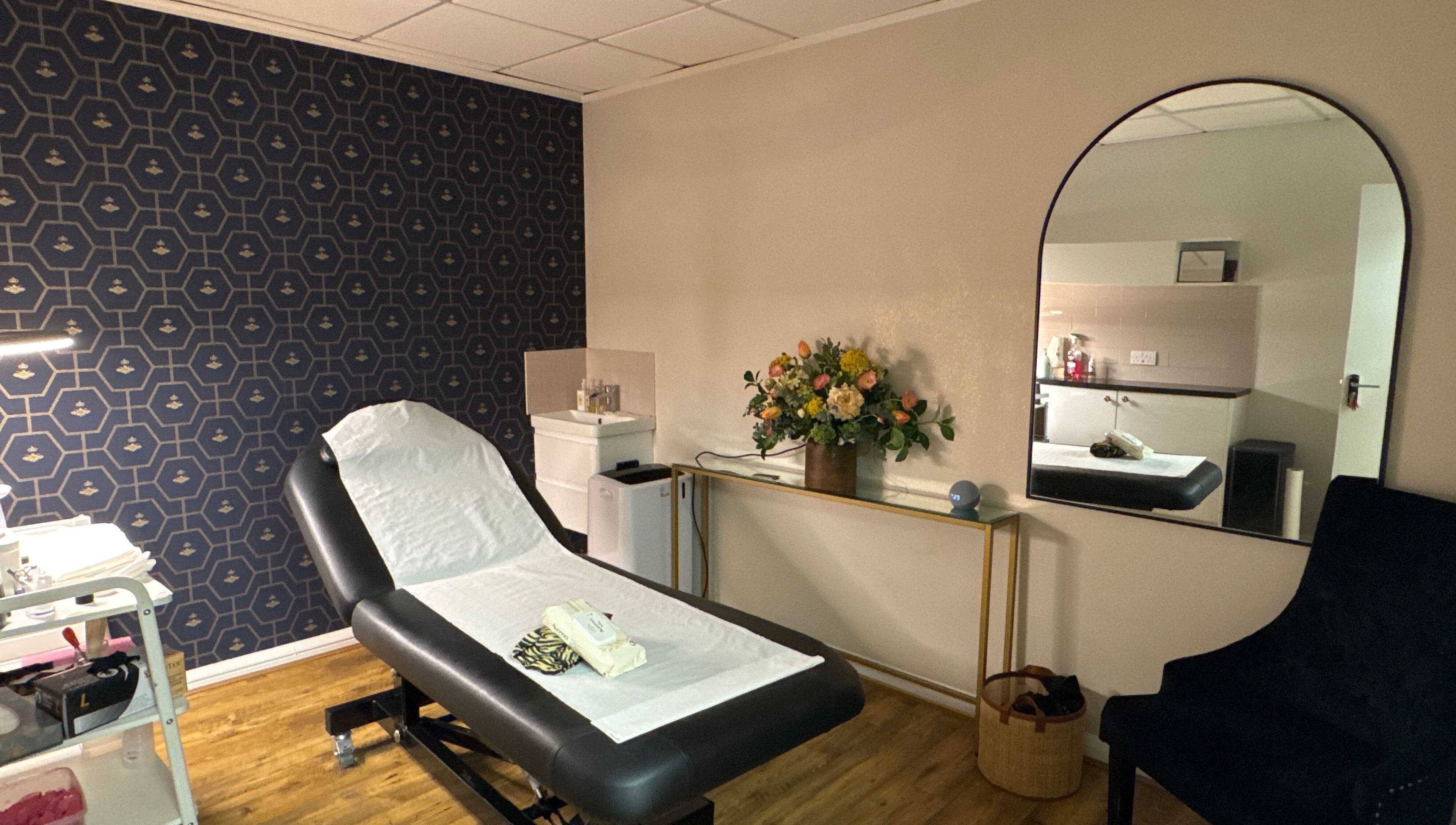 Elegant treatment room at Queen Bee Waxing Studio, Marlow, England, GB, featuring stylish decor and comfortable bed.