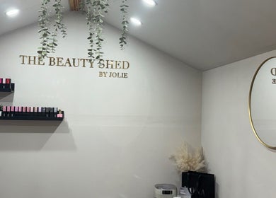 Interior of The Beauty Shed in Shaw, England, GB with shelves and a round mirror.