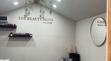 Interior of The Beauty Shed in Shaw, England, GB with shelves and a round mirror.