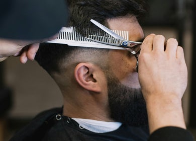 Expert barber performing haircut at Cal Poly Cuts in San Luis Obispo, California, US.