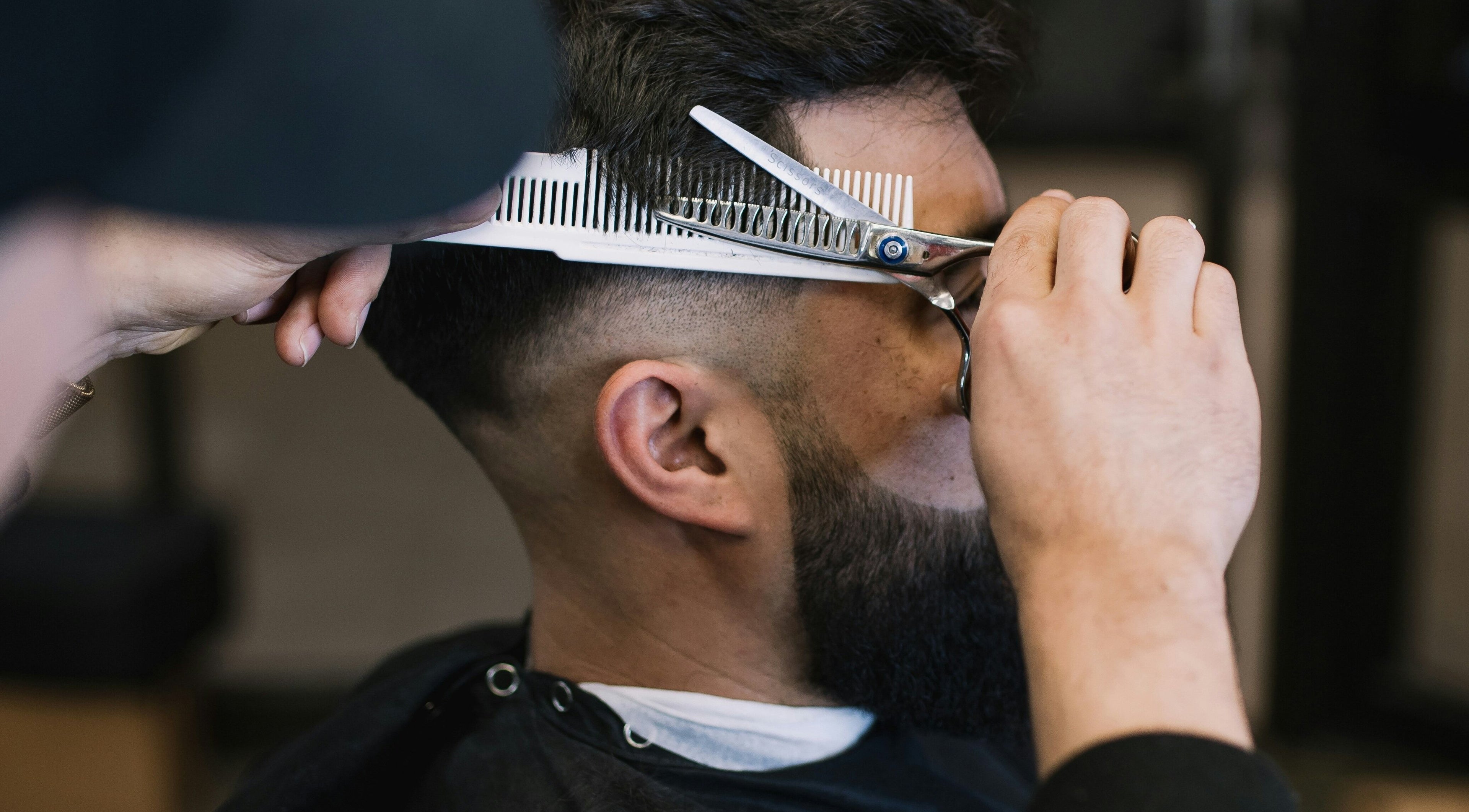 Expert barber performing haircut at Cal Poly Cuts in San Luis Obispo, California, US.