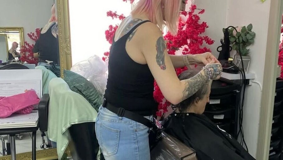 Hair stylist working at Stained Beauty Co, Arnold, England, GB with floral decor in background.