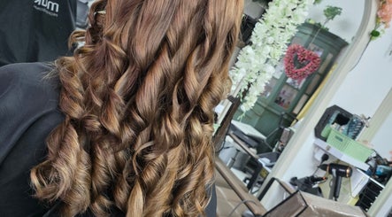 Stylish curled hairstyle at Stained Beauty Co salon in Arnold, England, GB with flower decor.