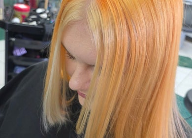 Hair coloring at Stained Beauty Co in Arnold, England, GB showcasing vibrant golden hues.