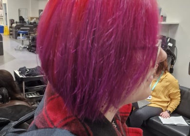 Vibrant magenta hairstyle at Stained Beauty Co in Arnold, England, GB. Modern salon setting.