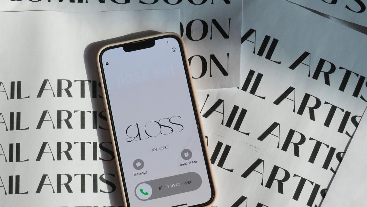 Phone screen showcasing Gloss Sets by Cay, Gqeberha, Eastern Cape, ZA with nail artist background.