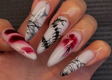 Intricate nail art at Nailsdonebyisabelle, Vaughan, Ontario, CA, featuring red and black floral designs.