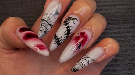 Intricate nail art at Nailsdonebyisabelle, Vaughan, Ontario, CA, featuring red and black floral designs.